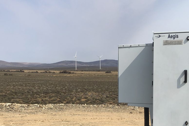 Close up of Aegis plus with wind turbines in background